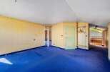 This spacious room features a vibrant blue carpet, complemented by light yellow walls and a decorative border.