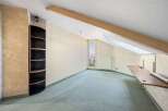 Discover the potential of this unique property! This space features a built-in shelving unit, a skylight, and a cozy atmosphere.