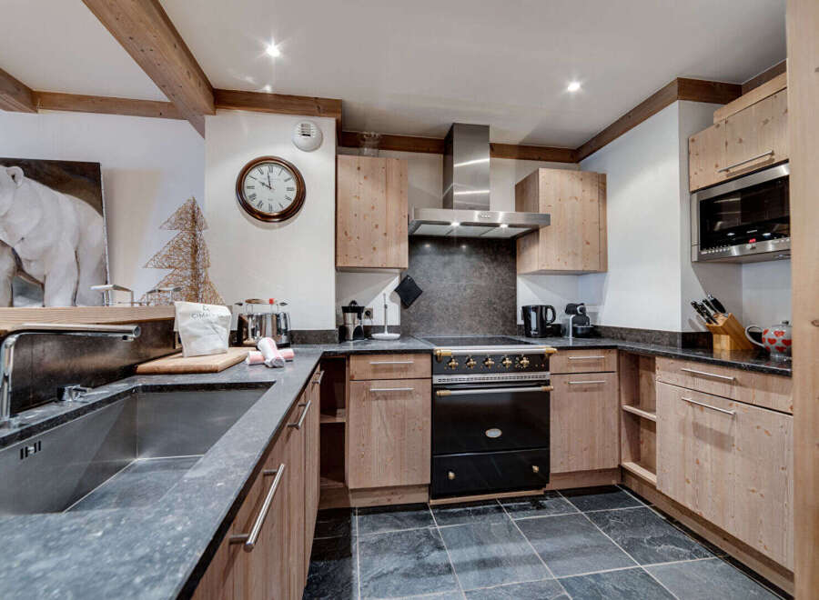 This stunning kitchen boasts a rustic charm with its wooden cabinetry and exposed beams, creating a warm and inviting atmosphere.