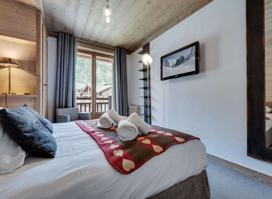 Experience the charm of this cozy bedroom, featuring a rustic wooden ceiling and walls that exude warmth.