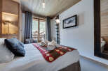 Experience the charm of this cozy bedroom, featuring a rustic wooden ceiling and walls that exude warmth.