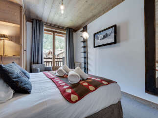 Experience the charm of this cozy bedroom, featuring a rustic wooden ceiling and walls that exude warmth.