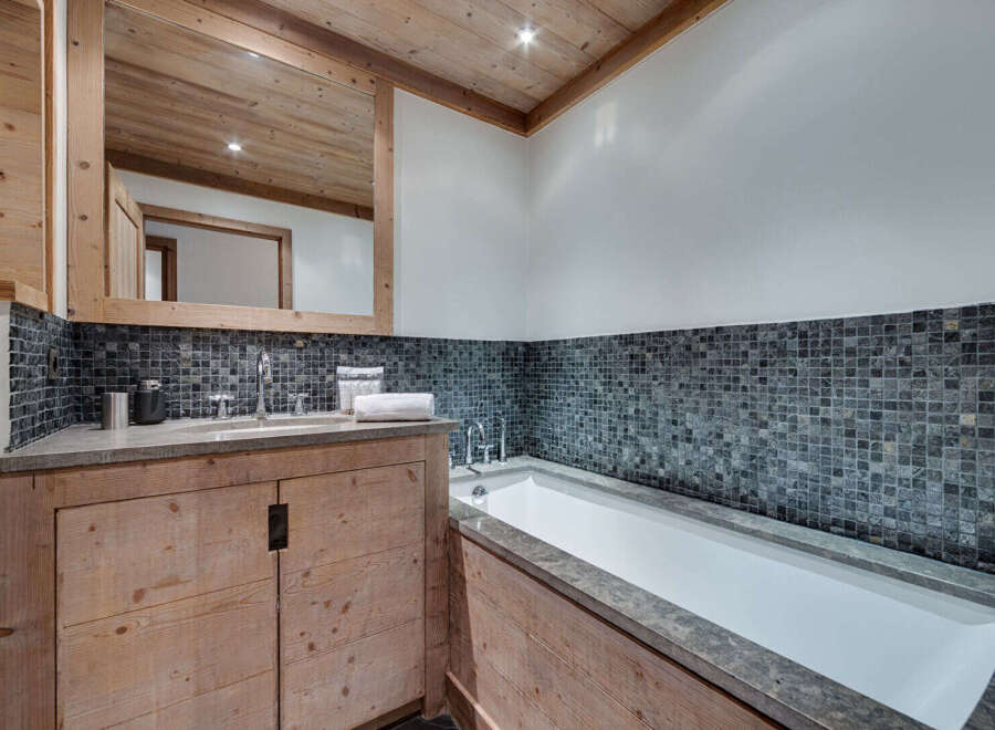 This luxurious bathroom features a stunning combination of natural wood and stone elements.