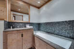 This luxurious bathroom features a stunning combination of natural wood and stone elements.