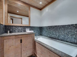 This luxurious bathroom features a stunning combination of natural wood and stone elements.
