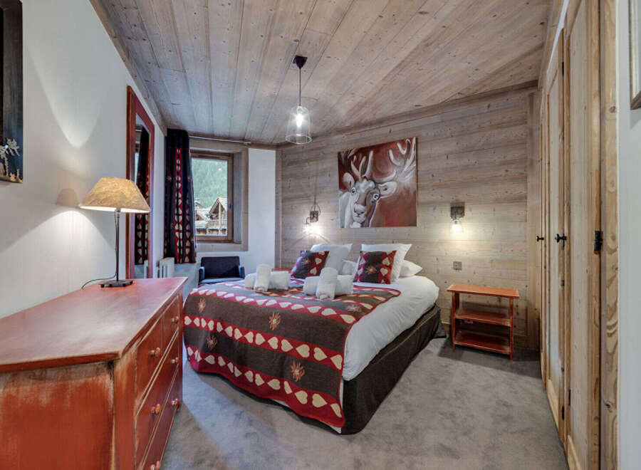 Experience the charm of this cozy bedroom, featuring rustic wooden accents and a warm, inviting atmosphere.
