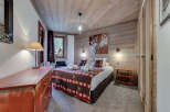 Experience the charm of this cozy bedroom, featuring rustic wooden accents and a warm, inviting atmosphere.