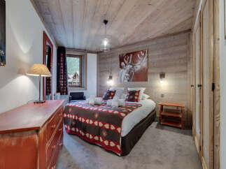 Experience the charm of this cozy bedroom, featuring rustic wooden accents and a warm, inviting atmosphere.