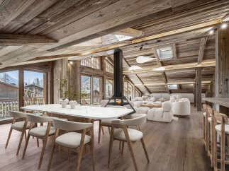 Experience luxury living in this stunning chalet, featuring a spacious open-plan design with exposed wooden beams and large windows offering breathtaking mountain views.