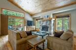 Experience the warmth of this stunning living room, featuring a cozy fireplace and a beautiful wooden ceiling.