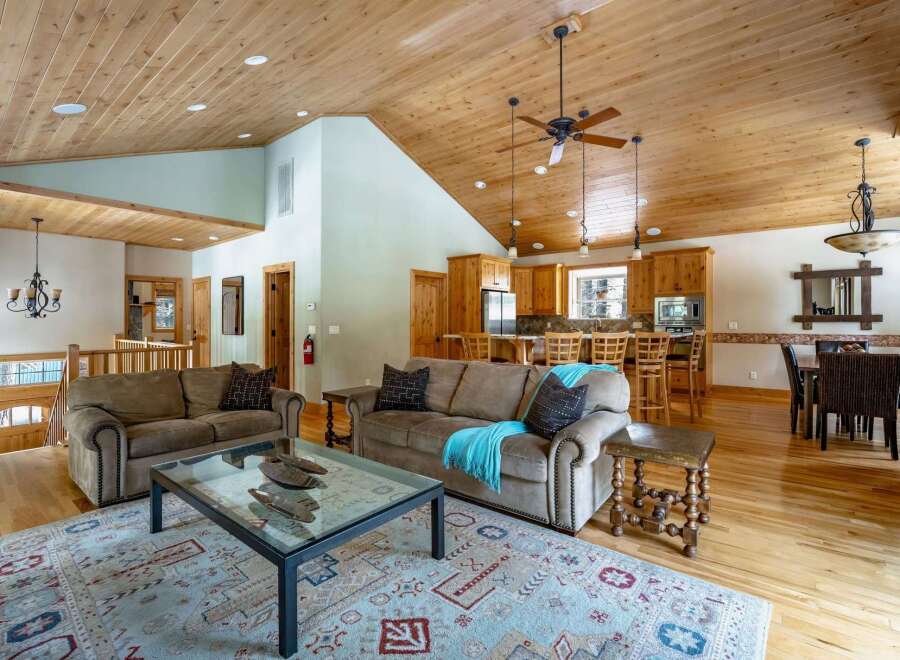 This stunning property boasts a spacious open-concept living area with a beautiful wooden ceiling and hardwood floors.
