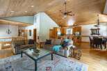 This stunning property boasts a spacious open-concept living area with a beautiful wooden ceiling and hardwood floors.