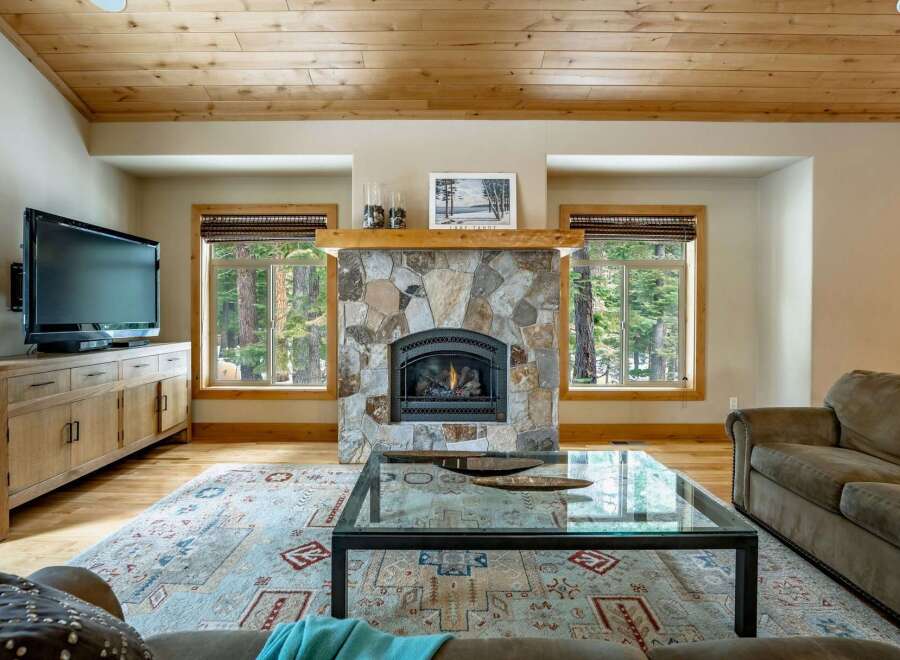 Experience the warmth of this stunning living room, featuring a cozy fireplace and a stylish coffee table.
