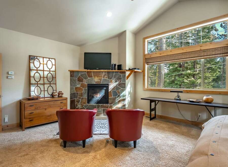 This cozy living space features a stunning stone fireplace, perfect for those chilly evenings.