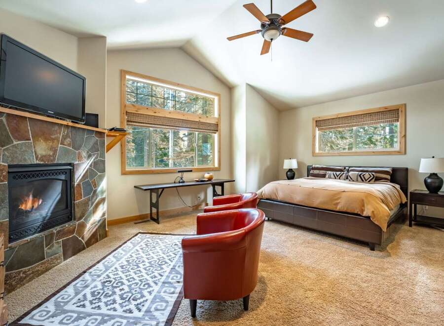 This stunning bedroom features a cozy fireplace with a mounted TV, perfect for relaxing evenings.