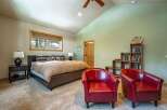 This inviting bedroom boasts a cozy atmosphere with its plush carpet and warm color palette.
