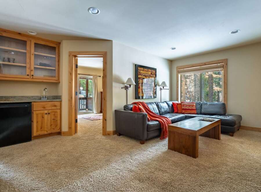 This stunning property features a cozy living area with a comfortable sectional sofa and a warm, inviting atmosphere.