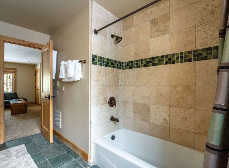 Step into luxury with this stunning bathroom featuring elegant tile work and a relaxing bathtub.