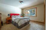 This cozy bedroom features a vibrant red headboard, creating a focal point against the neutral walls.