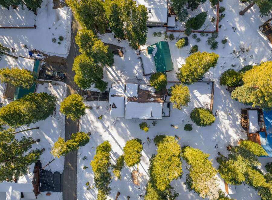 Nestled amidst a winter wonderland, this charming property boasts a cozy cabin with a snow-covered roof.