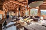 This stunning chalet boasts a warm and inviting interior with exposed wooden beams and a cozy fireplace.