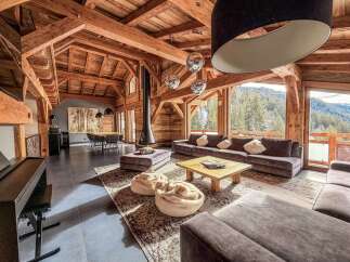 This stunning chalet boasts a warm and inviting interior with exposed wooden beams and a cozy fireplace.