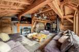 Experience luxury living in this stunning chalet-style home, featuring exposed wooden beams and a cozy fireplace.