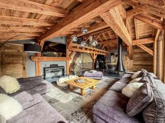 Experience luxury living in this stunning chalet-style home, featuring exposed wooden beams and a cozy fireplace.
