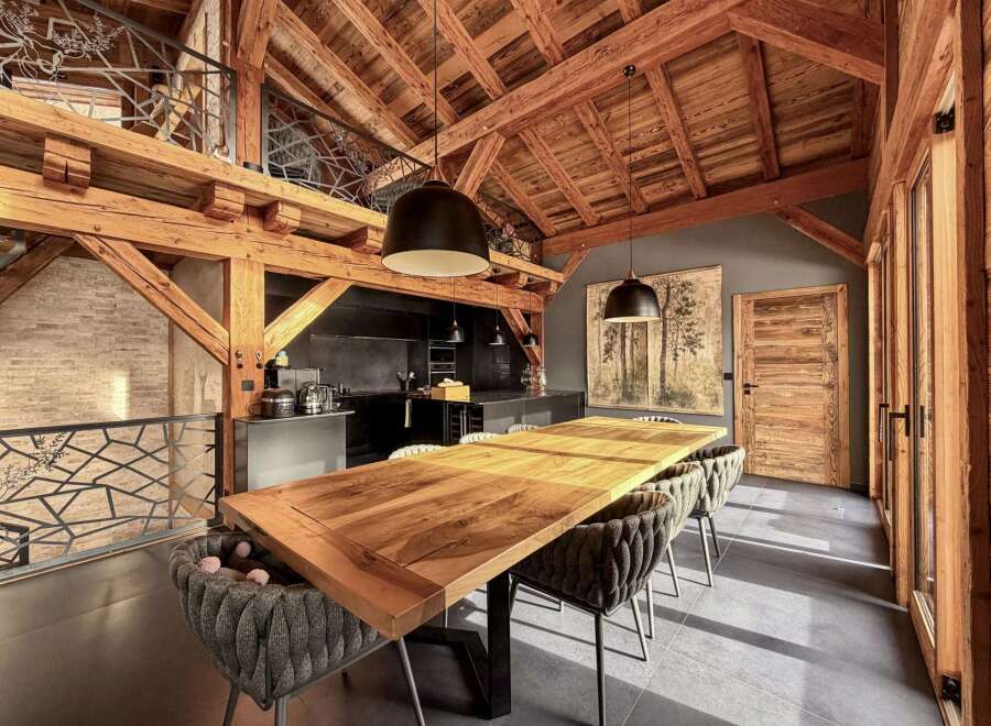 This stunning property boasts a unique architectural design with exposed wooden beams and a loft area, creating a warm and inviting atmosphere.