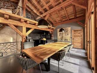 This stunning property boasts a unique architectural design with exposed wooden beams and a loft area, creating a warm and inviting atmosphere.