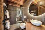 Experience luxury in this stunning bathroom! Featuring a modern design with a sleek glass shower, a stylish sink, and a beautiful wooden vanity.