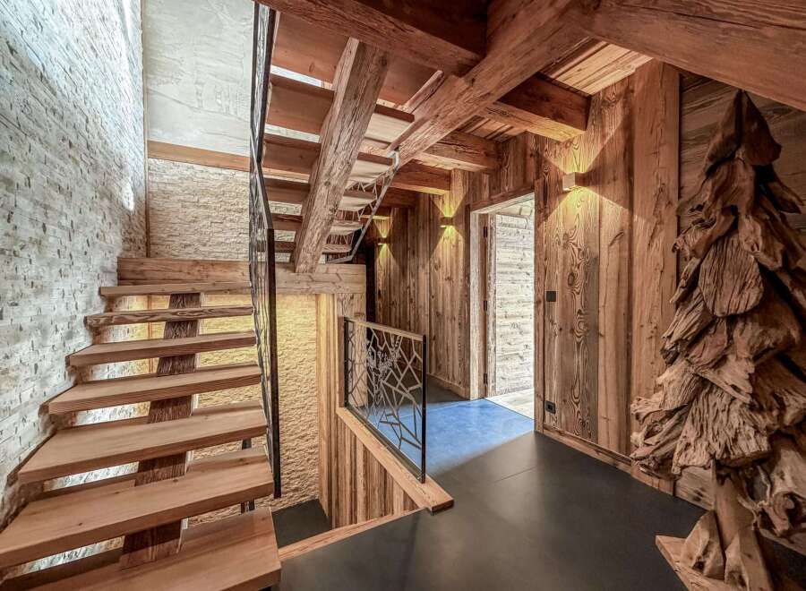 Step into rustic elegance with this stunning property featuring a beautifully crafted wooden staircase and exposed beams.