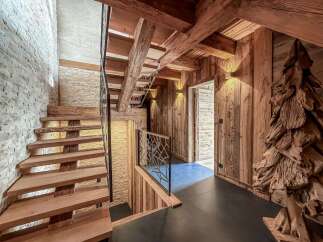 Step into rustic elegance with this stunning property featuring a beautifully crafted wooden staircase and exposed beams.