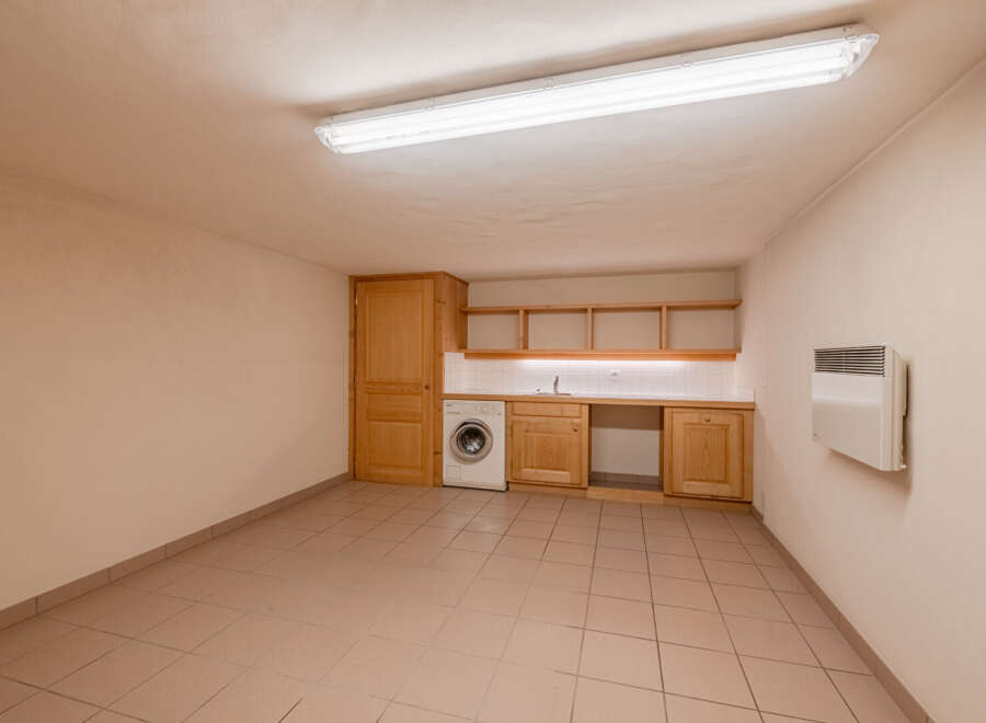 Discover the potential of this versatile space! This room features a functional laundry area with a washing machine and ample counter space.