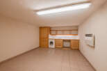 Discover the potential of this versatile space! This room features a functional laundry area with a washing machine and ample counter space.