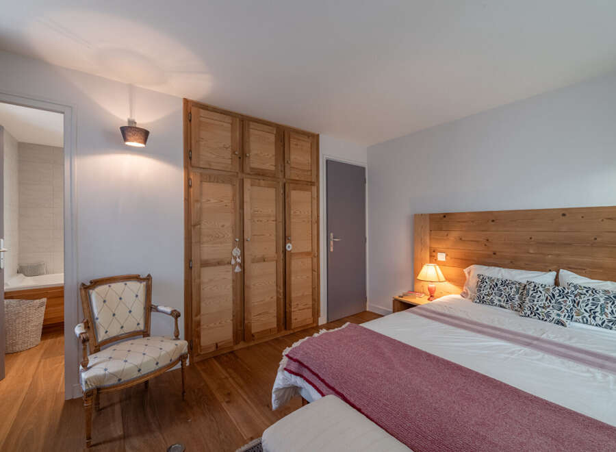 Discover the charm of this inviting bedroom, featuring a warm wooden headboard and a cozy ambiance.
