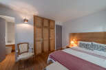 Discover the charm of this inviting bedroom, featuring a warm wooden headboard and a cozy ambiance.