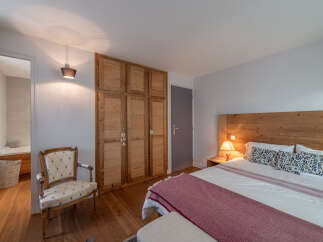 Discover the charm of this inviting bedroom, featuring a warm wooden headboard and a cozy ambiance.