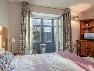 This charming bedroom offers a cozy retreat with its inviting ambiance and natural light.