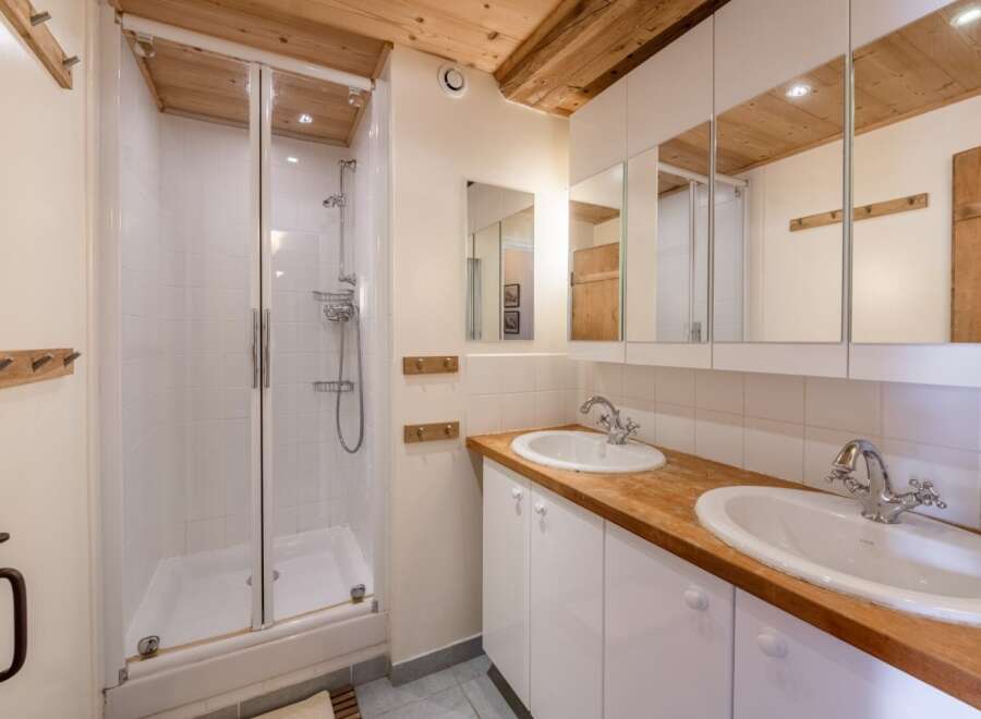 This charming bathroom features a glass-enclosed shower, perfect for a refreshing start to your day.