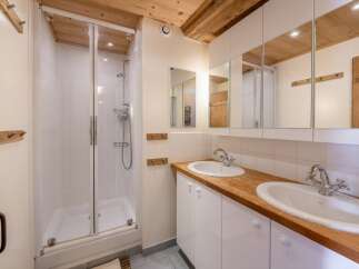 This charming bathroom features a glass-enclosed shower, perfect for a refreshing start to your day.