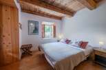 This charming bedroom features a cozy atmosphere with wooden beams and flooring, creating a warm and inviting space.