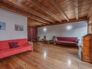 This charming living space features a warm, inviting atmosphere with its wooden floors and exposed beams.