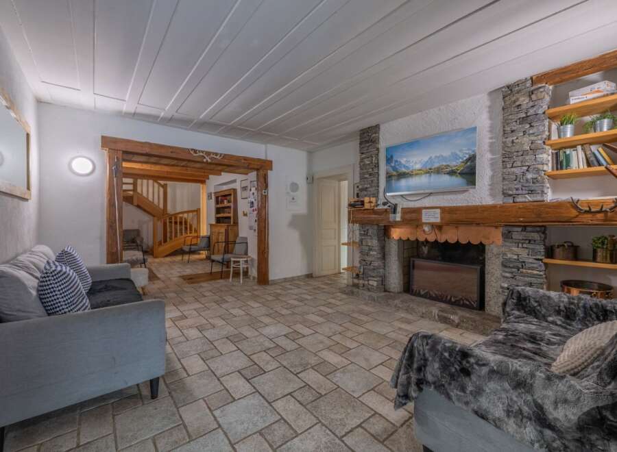 Step into a cozy living space featuring a stunning stone fireplace and a large screen TV, perfect for relaxing evenings.