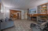Step into a cozy living space featuring a stunning stone fireplace and a large screen TV, perfect for relaxing evenings.