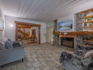 Step into a cozy living space featuring a stunning stone fireplace and a large screen TV, perfect for relaxing evenings.