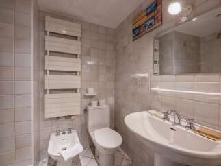 This charming bathroom features a classic design with tiled walls and a pedestal sink.