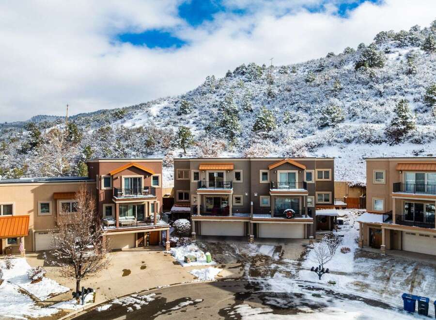 Discover luxury living in this stunning townhome community nestled against a snow-covered mountain backdrop.
