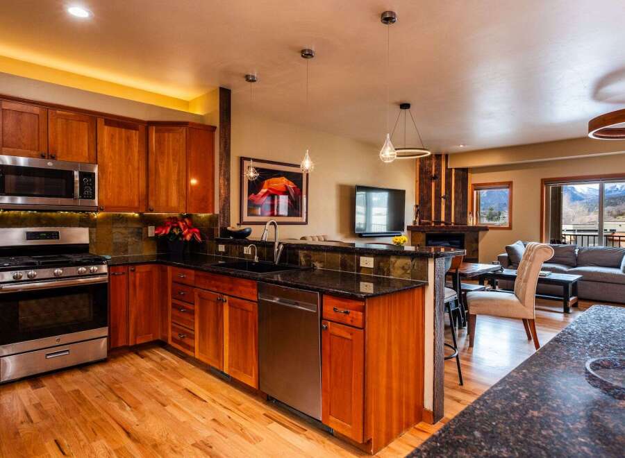 This stunning kitchen boasts beautiful wooden cabinetry, stainless steel appliances, and sleek granite countertops, creating a warm and inviting atmosphere.
