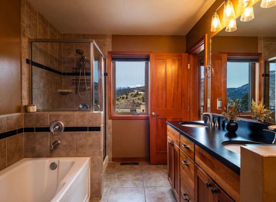 Step into luxury with this stunning bathroom featuring a spacious shower and a relaxing bathtub.